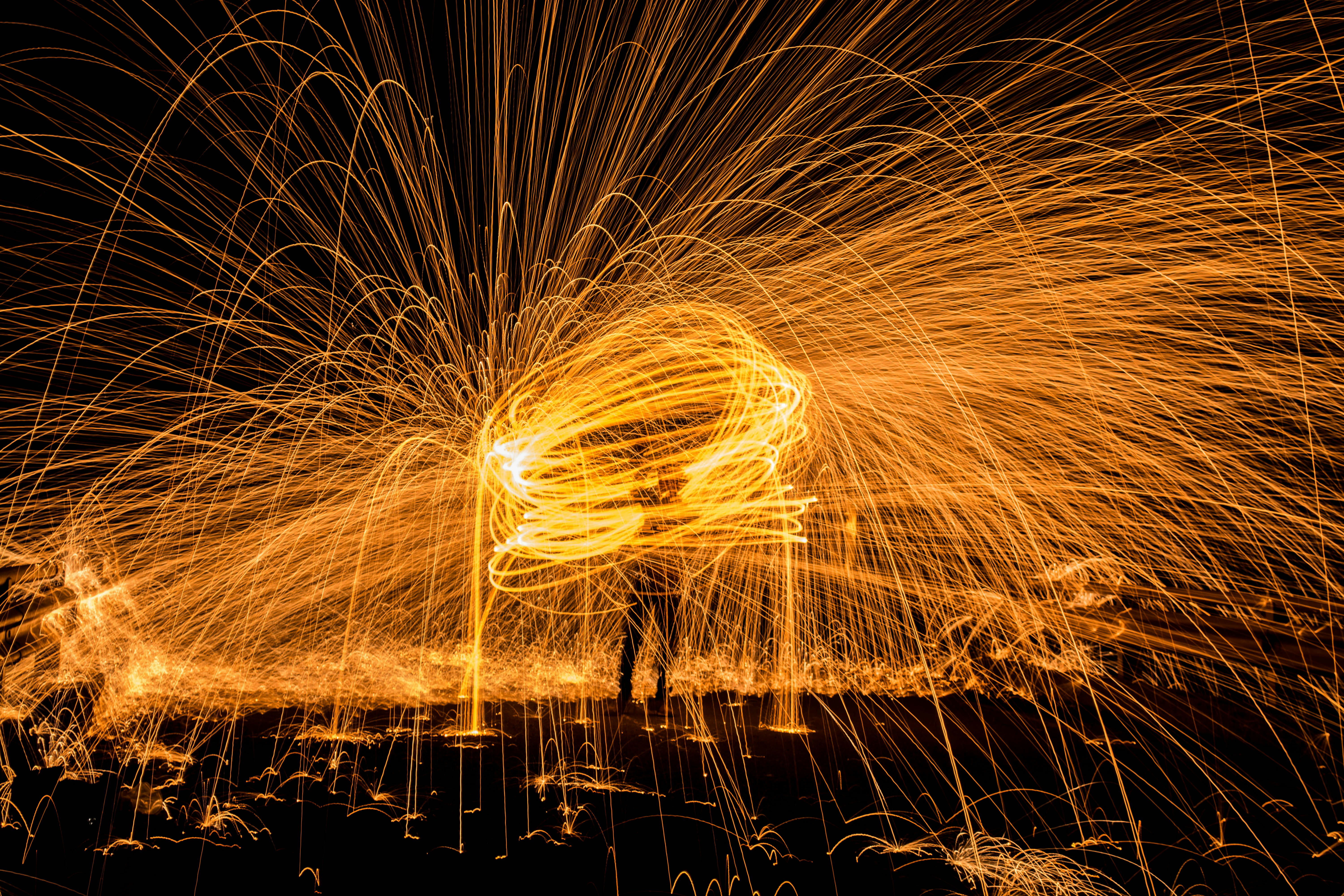 steel wool photography on man standing on black surface